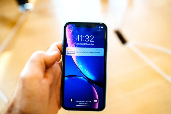 法国巴黎 2018年10月26日 在推出当天 在新的智能手机上使用液体视网膜主屏幕 男子手拿着最新的蓝色 Iphone 智能手机在苹果商店电脑 — 图库照片