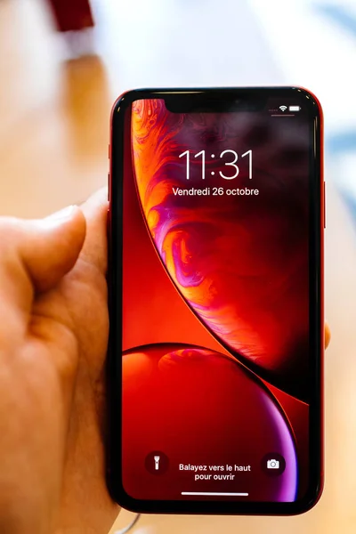 法国巴黎 2018年10月26日 在推出日的新智能手机与液体视网膜锁屏垂直时 男子手拿着最新的红色 Iphone 智能手机在苹果商店电脑 — 图库照片