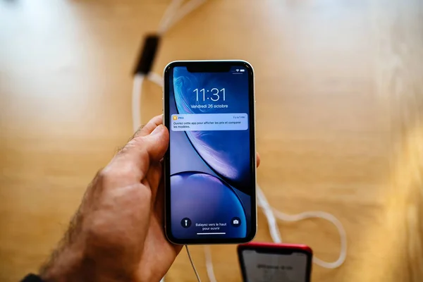 法国巴黎 苹果应用商店电脑新 Iphone 智能手机在推出当天在男性手欣赏蓝色手机液体视网膜显示屏 — 图库照片