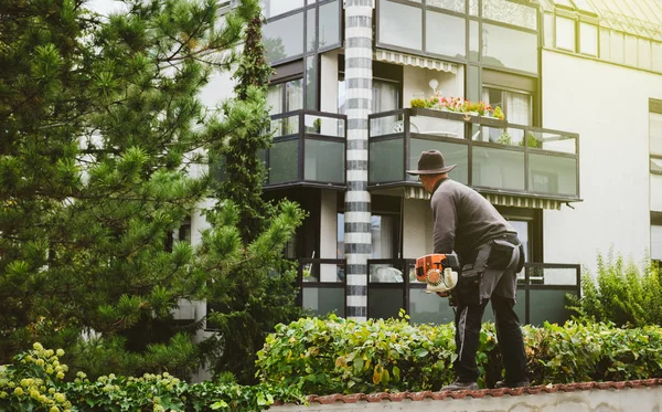 Hombre jardinero usando sierra eléctrica — Foto de Stock