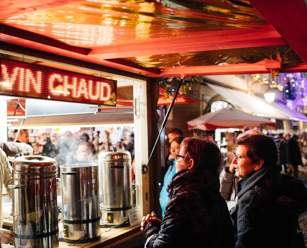 Twee volwassen vrouwen kopen glühwein op kerstmarkt — Stockfoto