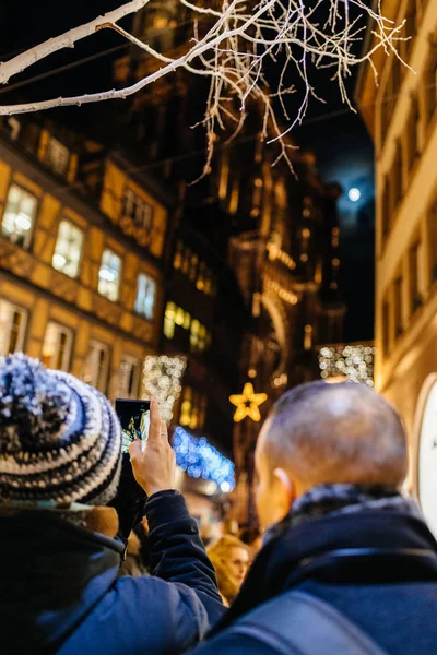 Pareja masculina tomando fotos de Notre-Dame y Navidad Market deco — Foto de Stock