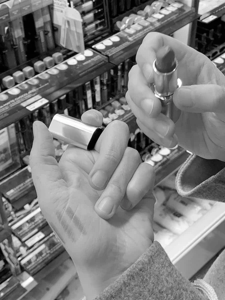 Woman testing lipstick on back of the hand — Stock Photo, Image