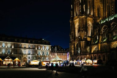 Strasbourg, Fransa - 29 Kasım 2017: Görkemli yer de Chateau yer keşfetmek yayalar ile Noel pazarı sırasında alacakaranlıkta ışıklı Notre-Dame de Strazburg Katedrali'ne birlikte