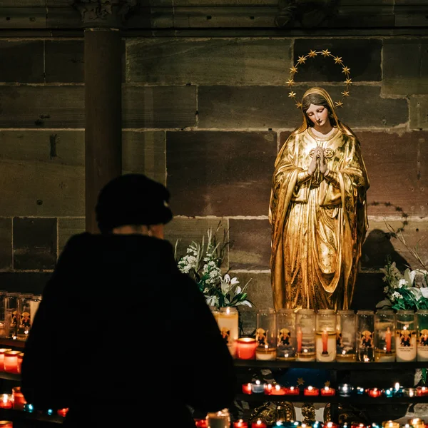 Mulher acende velas em Estrasburgo, França Catedral de Notre-Dame — Fotografia de Stock