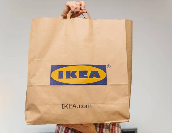 Γυναίκα με μεγάλο Ikea χαρτί τσάντα unboxing κρατώντας στο μέτωπο — Φωτογραφία Αρχείου