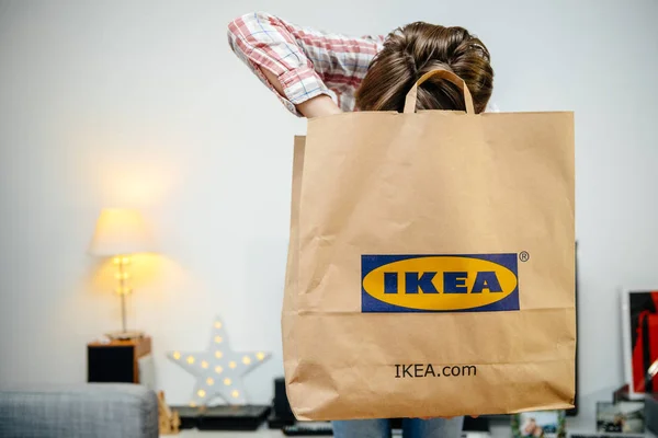 Büyük IKEA kağıt çanta unboxing ile kadın — Stok fotoğraf