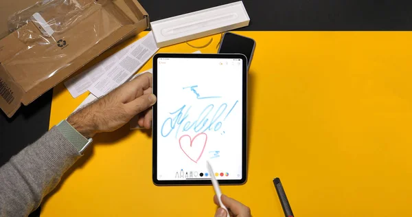 Людина малювання слово hellow на останній ipad Pro і Apple олівець — стокове фото