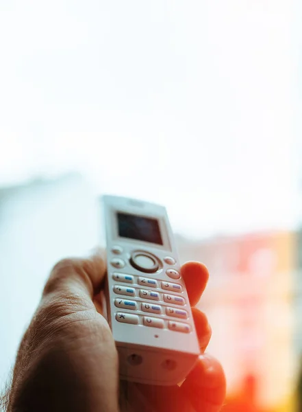 Man hand met draadloze telefoon bellen kantoor aan huis — Stockfoto