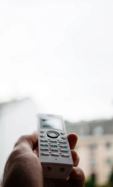 Hombre de mano sosteniendo el teléfono inalámbrico llamando a casa oficina —  Fotos de Stock