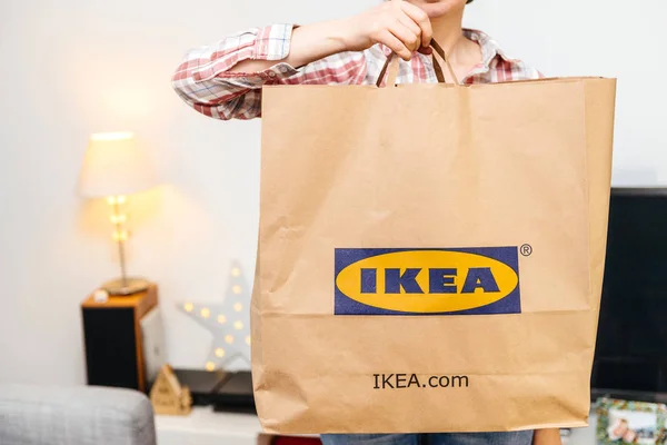 Frau mit großer Ikea-Papiertüte beim Auspacken — Stockfoto