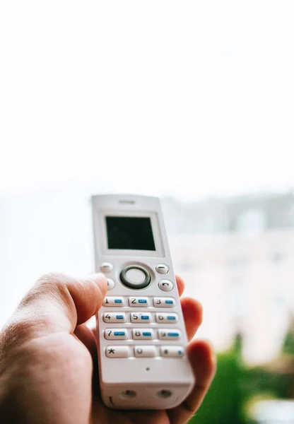 Homem mão segurando telefone sem fio chamando escritório em casa — Fotografia de Stock