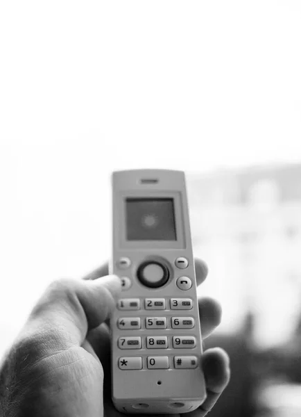 Uomo mano tenendo il telefono cordless chiamando ufficio a casa — Foto Stock