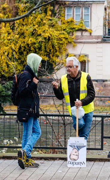 Homem de casaco amarelo e meia Cartaz de Emmanuel Macron — Fotografia de Stock