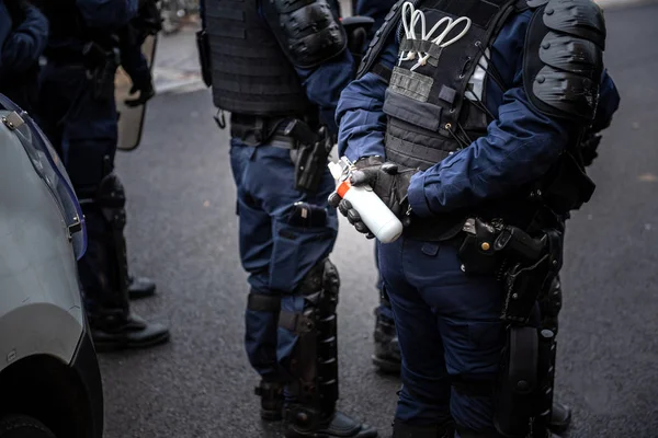 Policjant posiadający gazu łzawiącego, które są gotowe do użycia go w proteście w Fr — Zdjęcie stockowe