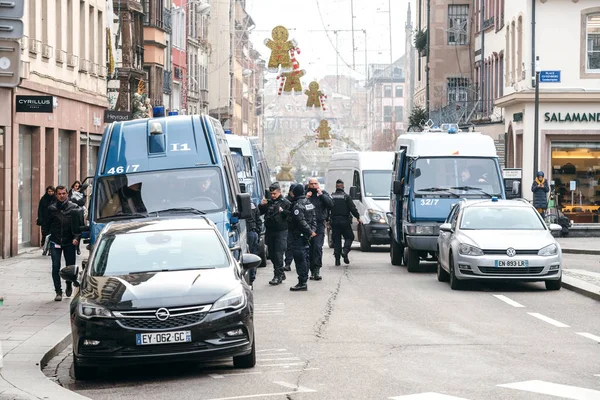 Camionete de poliție și un grup mare de ofițeri care supraveghează zona după o — Fotografie, imagine de stoc