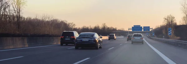 Tesla P85 y otros coches en la autopista alemana al atardecer — Foto de Stock