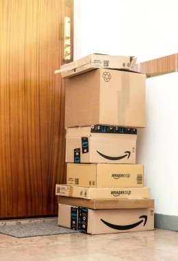 Kapının yanında düzenlenmiş birden fazla Amazon prime sipariş yığını