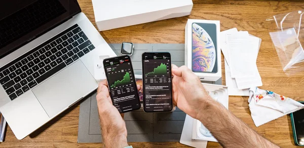 Hombre viendo la evolución del mercado de valores AAPL en el iPhone XS — Foto de Stock