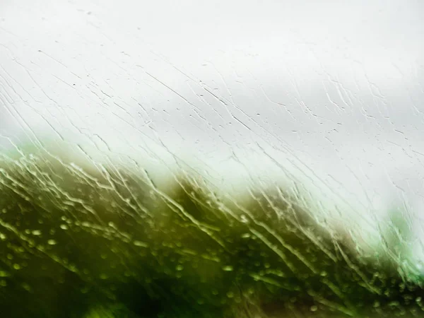 快速驾驶汽车上的挡风玻璃上有多个水滴 — 图库照片