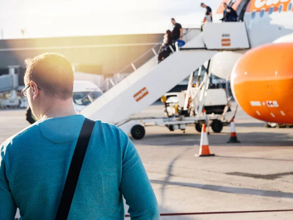 Hombre mirando a la gente descendiendo avión Easy Jet en internatio — Foto de Stock