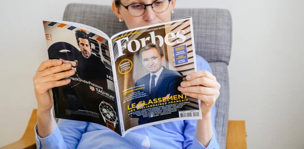 Žena čte Forbes seznam miliardářů Francie — Stock fotografie