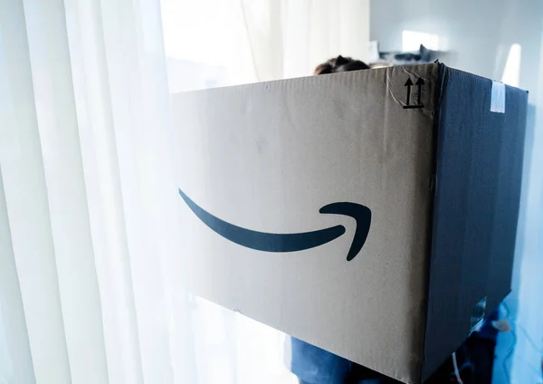 Wanita memegang besar Amazon Prime kardus paket — Stok Foto