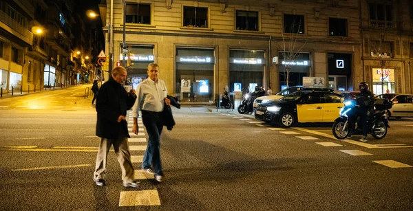 Hombres mayores cruzando la calle por la noche en Barcelona — Foto de Stock