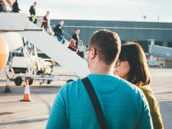 Mulher e homem perto do avião EasyJet com passageiros descendo escada — Fotografia de Stock