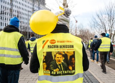 Posterlerini açmaları ile Gilets Jaunes protesto sırasında yürüyen gösteren insanlar