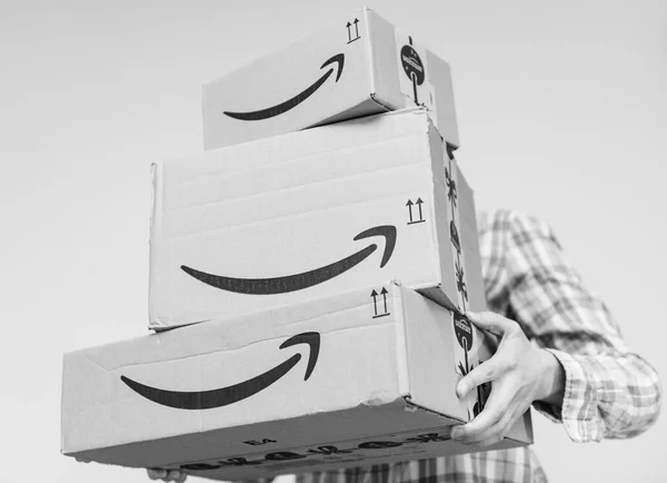 Frau hält drei große Amazon-Pakete in der Hand — Stockfoto