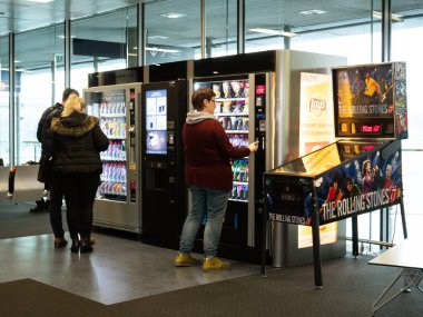 İnsanlar satın alma gıda ve aperatifler Havaalanı satış makinesi