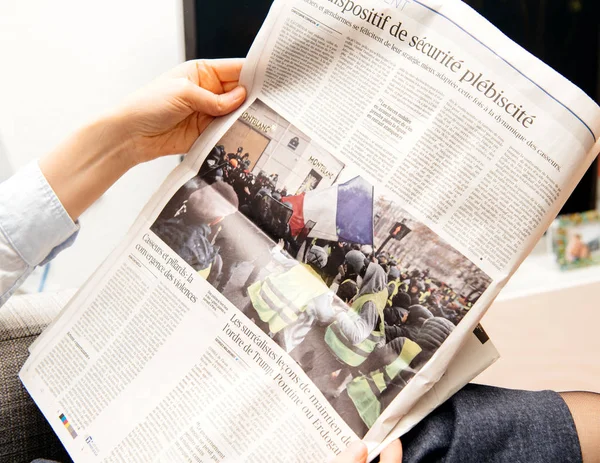 Mujer leyendo el periódico francés Le Figaro sobre las protestas francesas — Foto de Stock