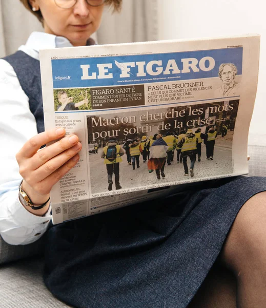 Женщина, читающая французскую газету Le Figaro — стоковое фото