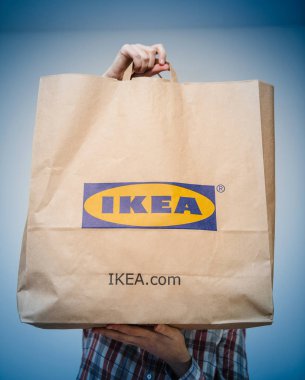 Kadın gösteren sunan IKEA kağıt çanta mal