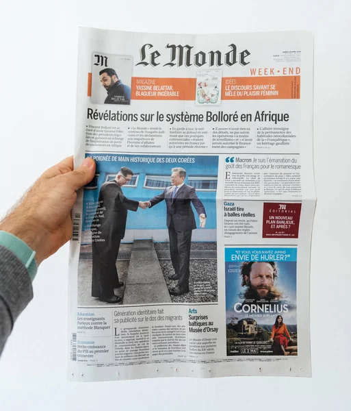 Mano de hombre sosteniendo el periódico francés Le Monde — Foto de Stock