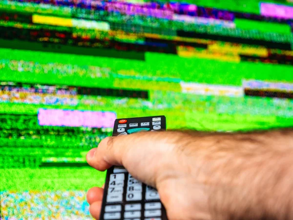 Männliche Handfernbedienung auf der Suche nach einem guten Signal im Fernseher — Stockfoto