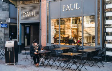 Kruvasan yeme ve içme kahve Paul kafede yalnız kadın