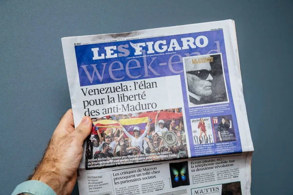 Człowiek posiadający gazety Le Figaro z worldwide wiadomości — Zdjęcie stockowe