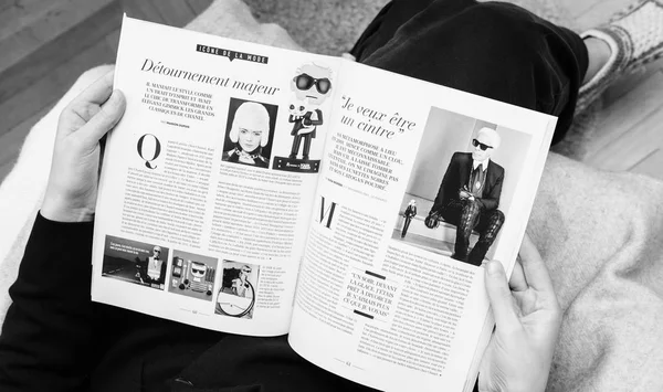 Женщина, читающая "Le Figaro Tribute" Карлу Лагерфельду — стоковое фото