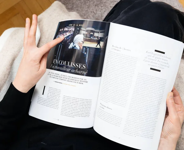 Женщина, читающая "Le Figaro Tribute" Карлу Лагерфельду — стоковое фото
