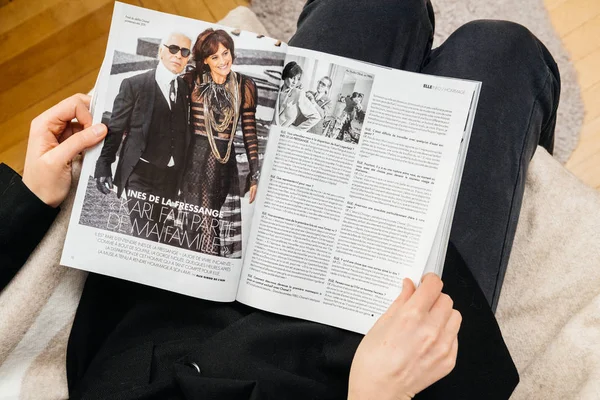 Mujer leyendo newsapepr sobre la muerte de Karl Lagerfeld en la revista Elle — Foto de Stock