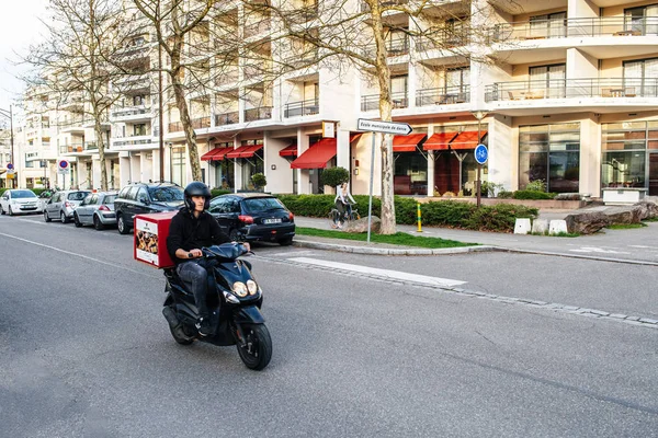 Hombre en scooter en las calles de Estrasburgo entregando sushi —  Fotos de Stock