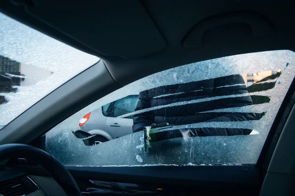 Mujer limpieza coche conductor ventana de heladas con hielo raspador de heladas —  Fotos de Stock