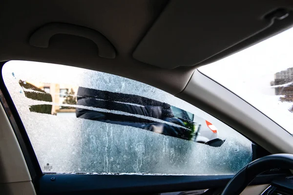 Woman cleaning car windshield from frost — Stock Photo, Image