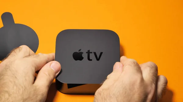 Apple TV unboxing against orange background — Stock Photo, Image