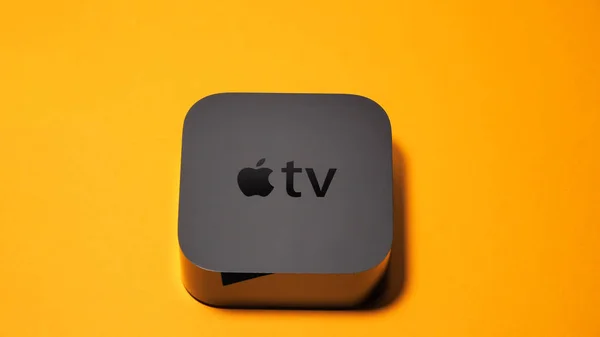 Apple Tv unboxing tegen oranje achtergrond — Stockfoto