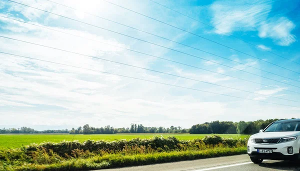 Hibrid elektromos Kia Suv vezetés napsütéses napon — Stock Fotó