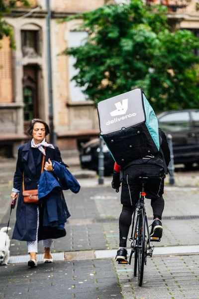 Rear view of Deliveroo cyclist fast cycling on French street — Stock Photo, Image