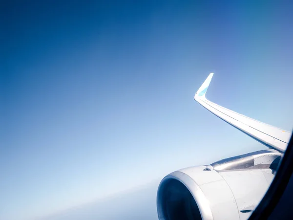 View from window of plane turbine in flight high above clouds — Stock Photo, Image